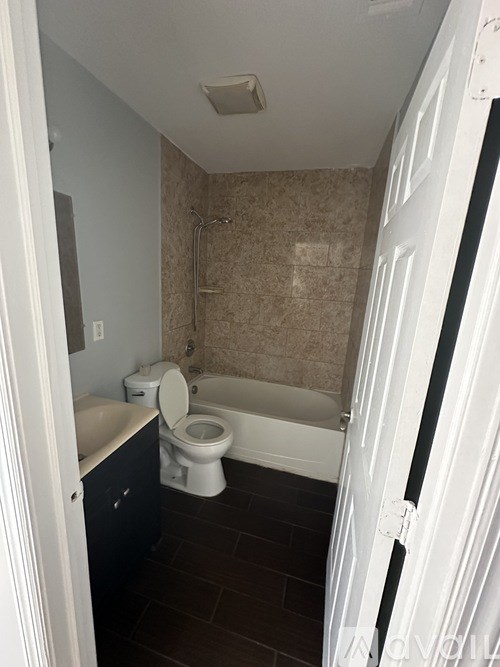 A bathroom with a toilet, tub, and sink.