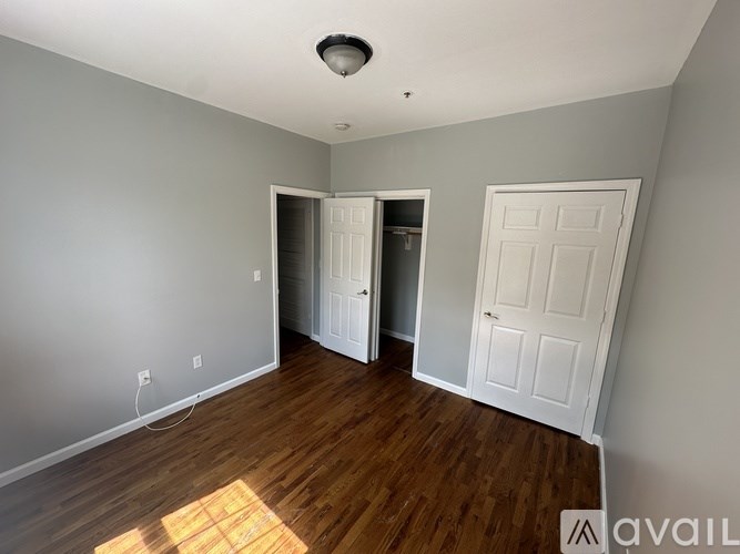 A room with a white door and a wooden floor.