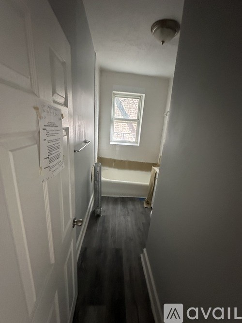 A hallway with a white door and a window.