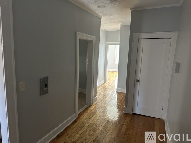 A room with a white door and a window with sunlight coming through.