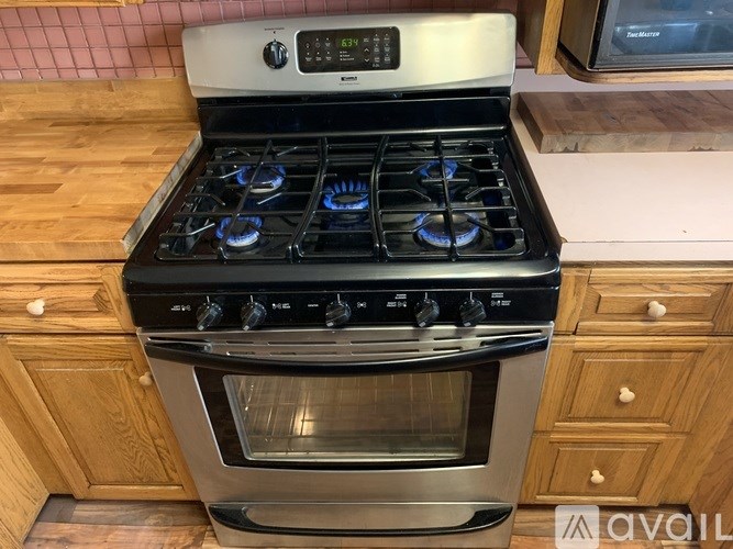 A modern stove with a stainless steel oven and a digital control panel.