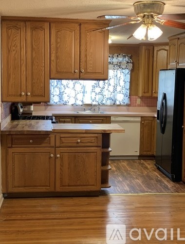 A hallway with wooden stairs and a black railing.