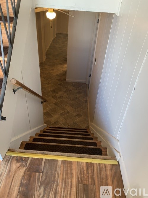 A staircase with wooden steps and a metal handrail.