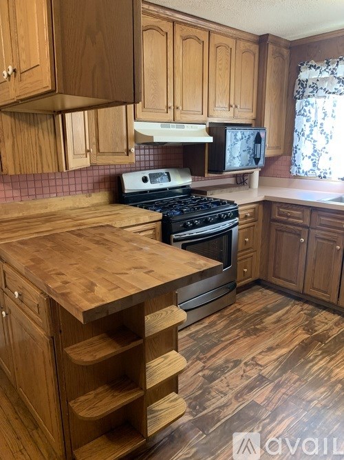A kitchen with wooden cabinets and a wooden counter top.