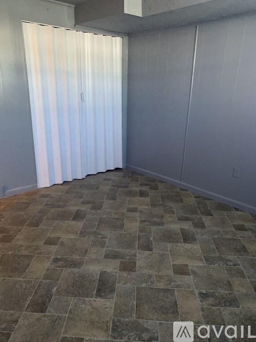 A room with a stone floor and a white curtain.