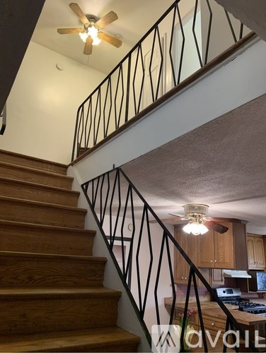 A black wrought iron gate with a number 62 on the wall behind it.