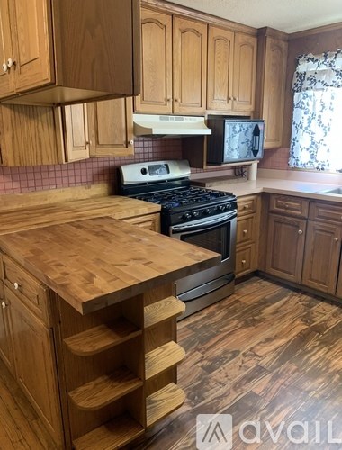 A room with a ceiling fan and wooden flooring.