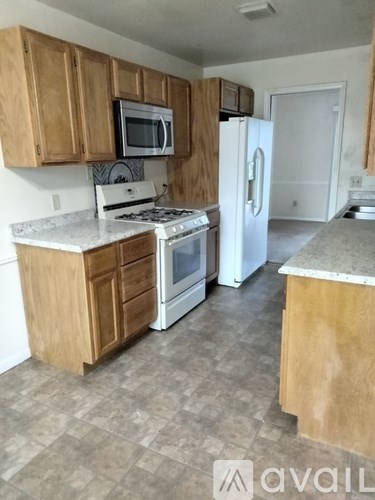 A kitchen with wooden cabinets and a white refrigerator.