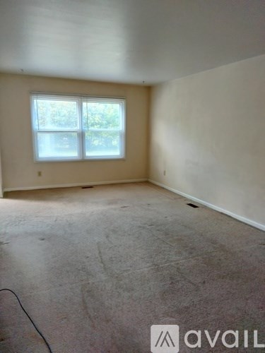 A room with a window and a wall with a cable running along it.