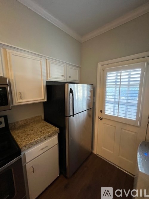 A kitchen with black and white appliances and cabinets.