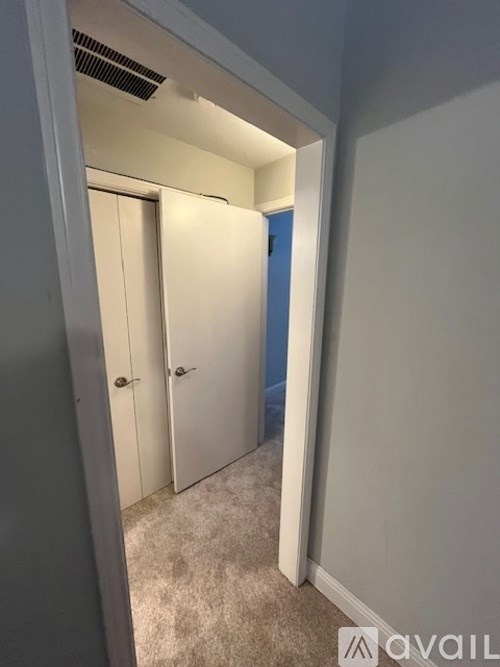 A hallway with two doors and a carpeted floor.