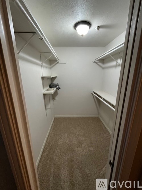 A small, empty room with a carpeted floor and a single light fixture on the ceiling.