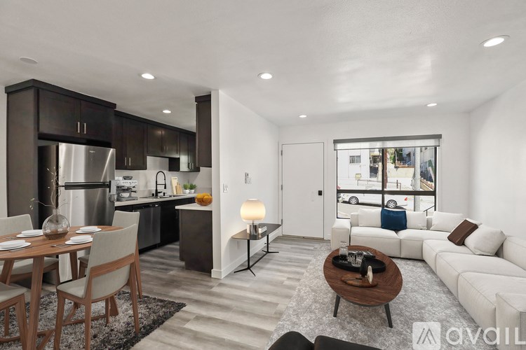 A modern kitchen with a dining table and a living room area.