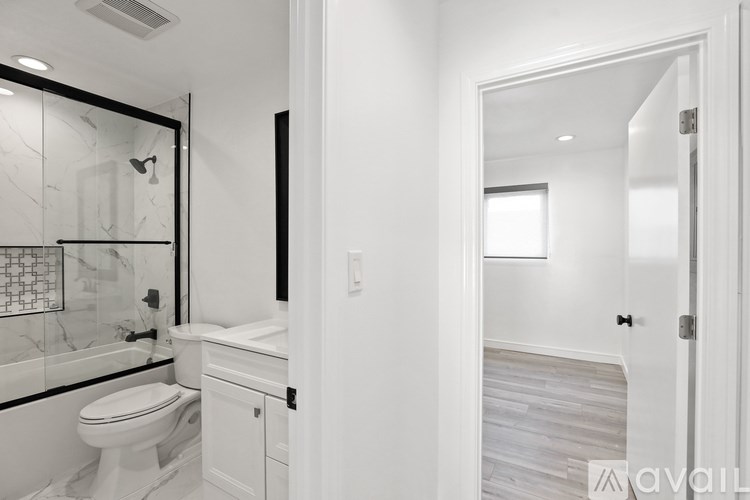 A bathroom with a toilet, sink, and mirror.