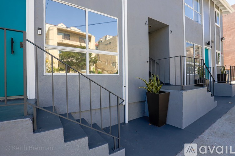 A building with a blue door and a potted plant on the steps.