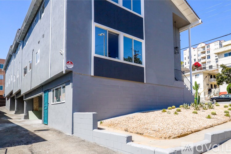 A grey building with a blue door and windows.