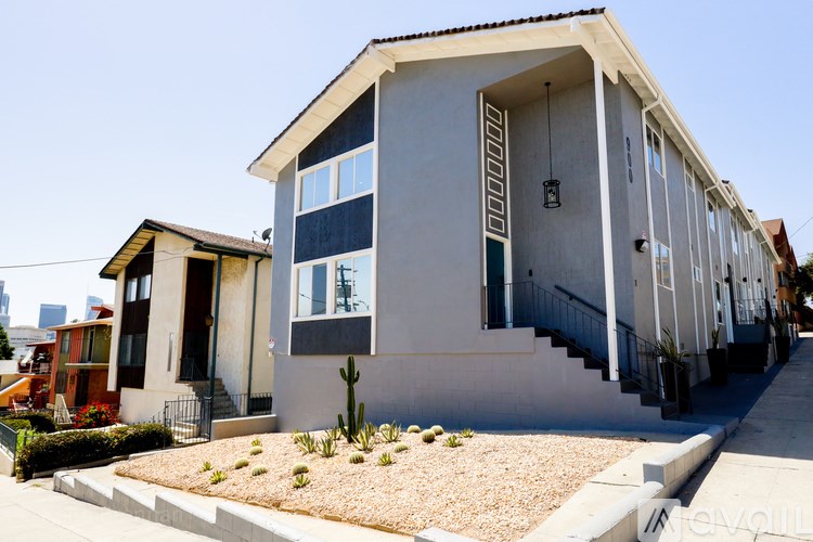 A modern house with a grey and white exterior and a black door.