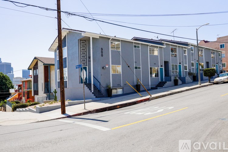 A street view of a row of houses with the first one being for sale.