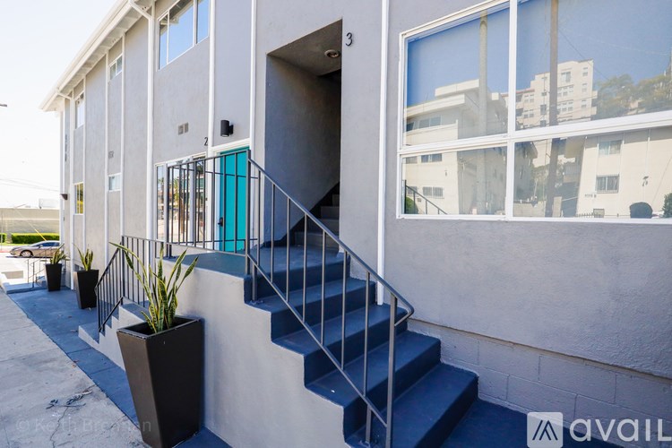 A modern house with a blue staircase and a glass window.