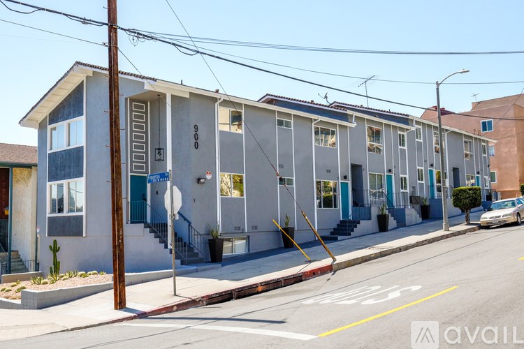 A street view of a residential area with houses and a car parked on the side of the road.