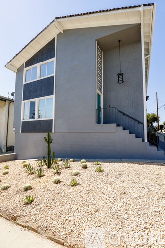 A house with a cactus garden in front.