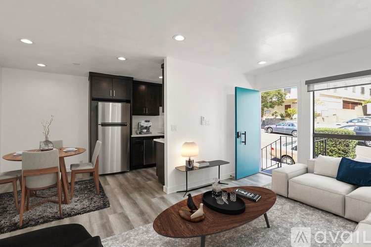 A modern living room with a dining area and a kitchen in the background.