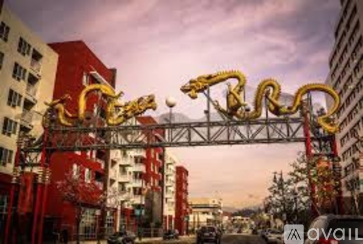 A golden dragon sculpture is displayed on a metal frame in an urban setting.