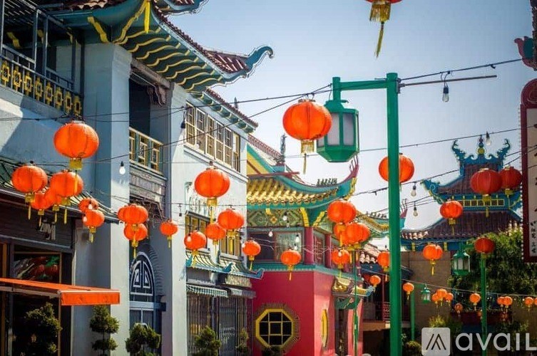 A street view of a Chinese temple with red lanterns hanging from the ceiling.