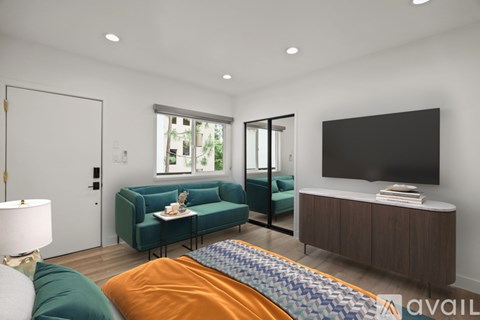 A modern living room with a green couch and a television.