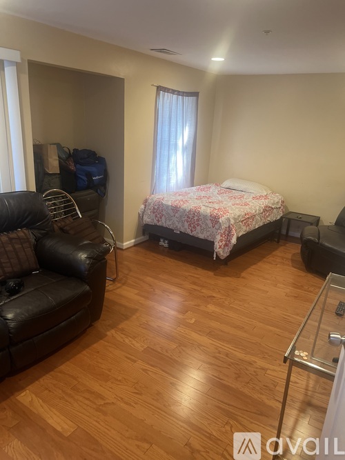 A bedroom with a bed, a couch, and a chair.