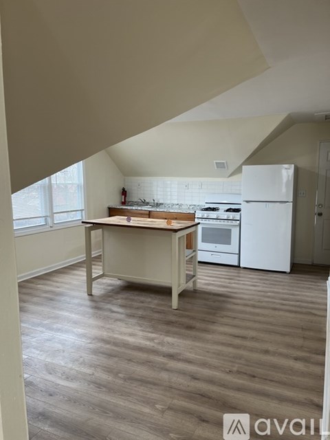 A kitchen with a white fridge and a table with a white tile backsplash.