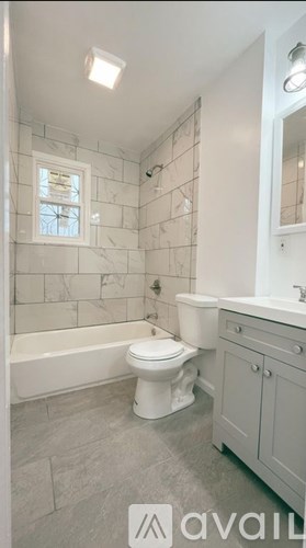 A white toilet and sink in a small bathroom.