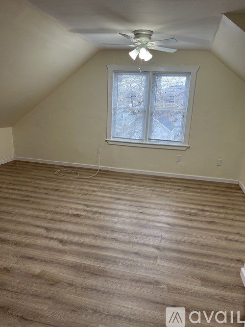 A room with a ceiling fan and a window with a view of a snowy landscape.