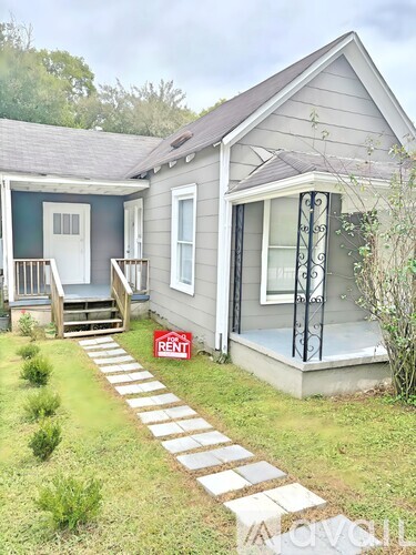 A house with a porch and a sign that says "RENT".