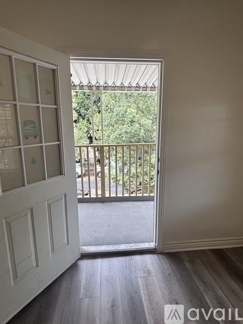 A room with a white door and a balcony with a railing.