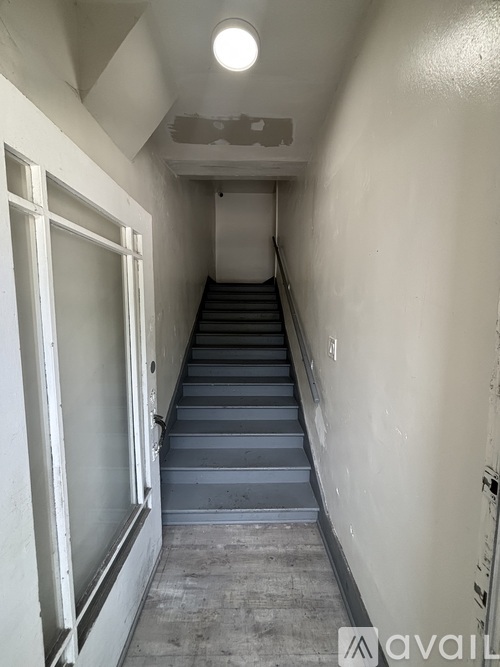 A long flight of concrete stairs leads up to a door.
