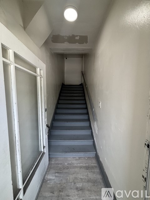 A long flight of concrete stairs leads up to a door.