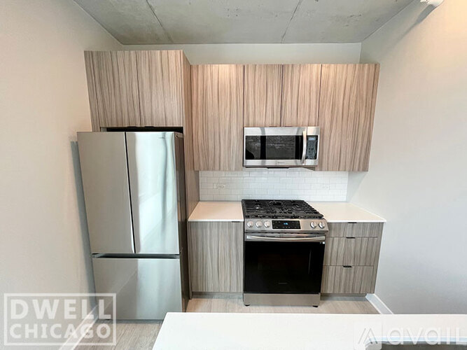 A modern kitchen with a refrigerator, oven, microwave, and sink.