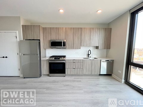 A modern kitchen with a refrigerator, oven, microwave, and sink.