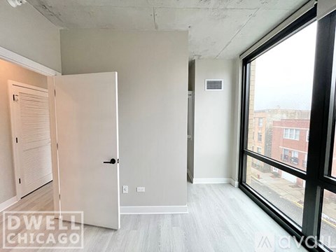 A white door is open to a room with a window.