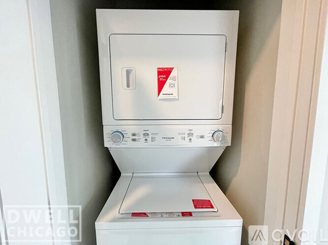A white dryer is sitting in a small space.