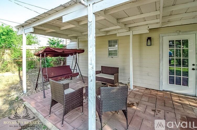 A patio with a table and chairs under a canopy.