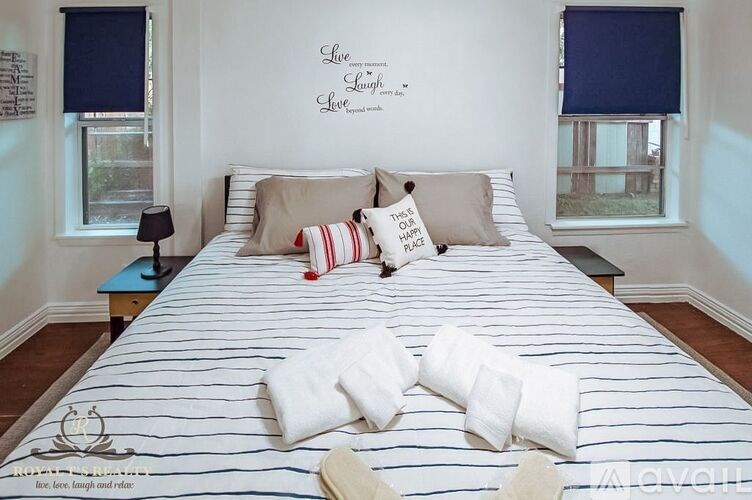 A bedroom with a bed, pillows, and a lamp.