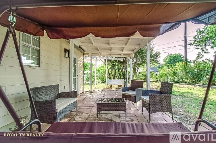 A patio with a table and chairs under a canopy.