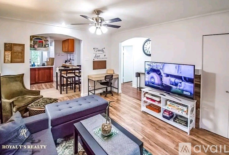 A living room with a television on a stand and a couch.