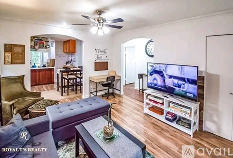 A living room with a television on a stand and a couch.