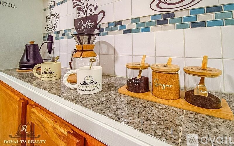 A coffee station with a coffee grinder, cups and a sign.