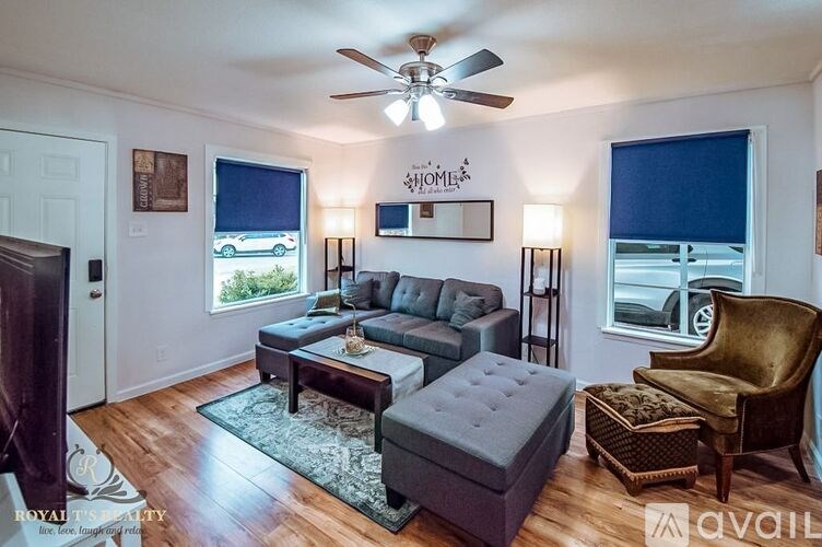 A living room with a grey couch, a brown chair, and a rug.