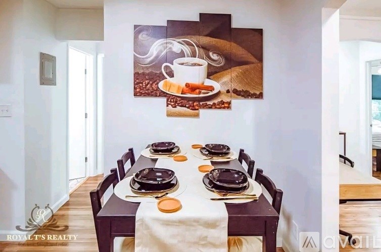A dining room with a table set for six and a coffee themed painting on the wall.