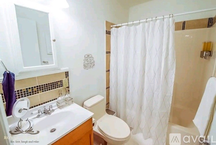 A white bathroom with a toilet, sink, and shower.